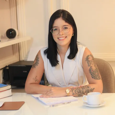Andressa Meneses sorrindo em seu espaço profissional