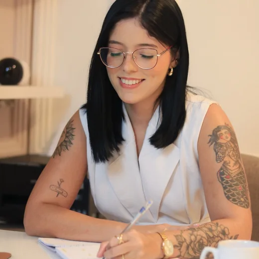 Andressa Meneses escrevendo em seu espaço de trabalho
